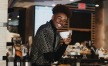 a man holding a cup of coffee in cafe